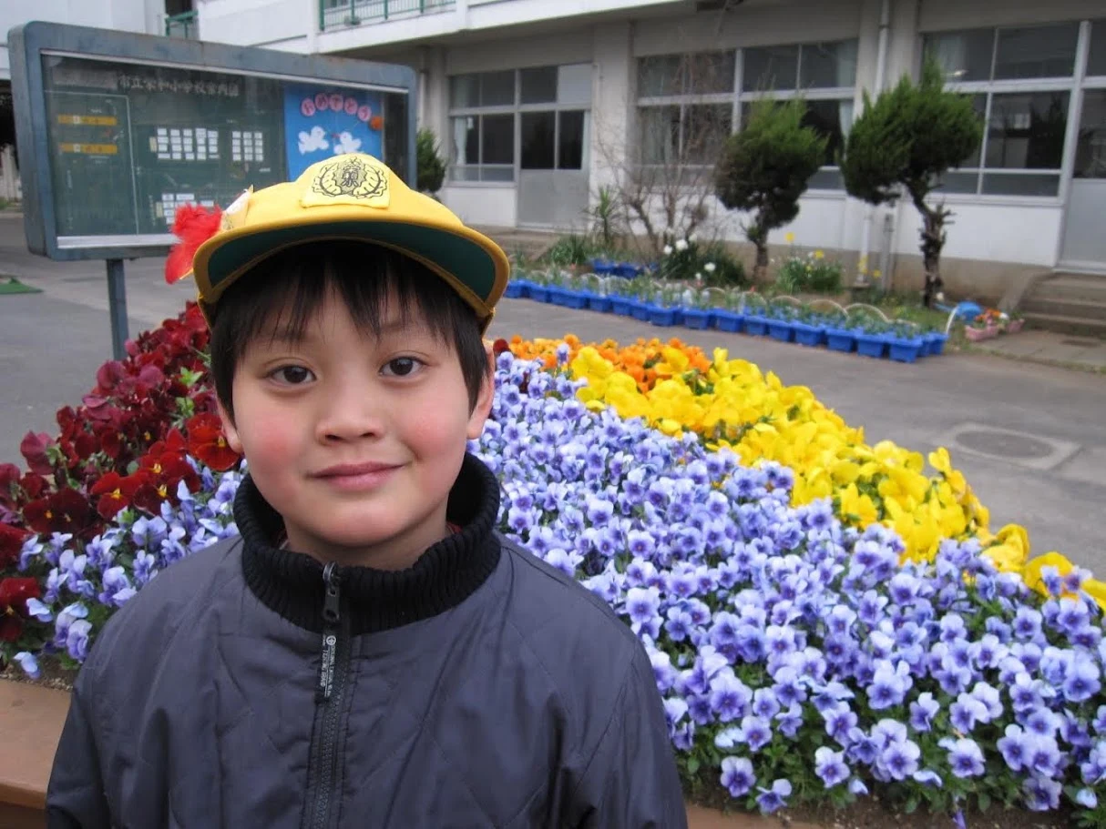 Childhood portrait beside a colorful flower garden