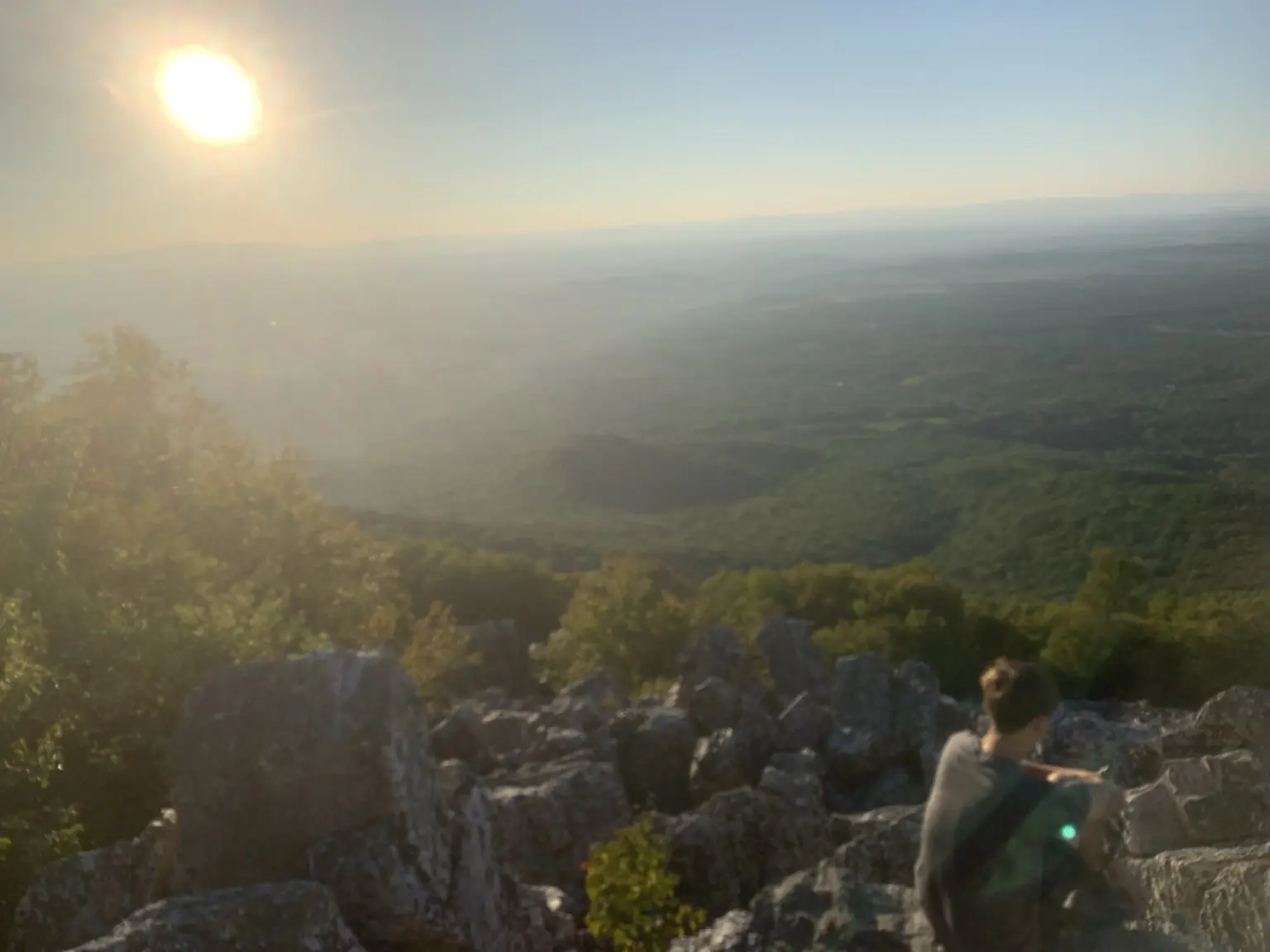 Hiker resting at a mountain overlook near sunset