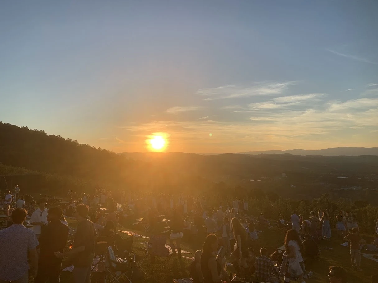 Sunset over distant hills with a gathering in the foreground